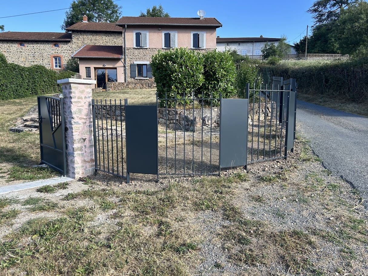 Fabrication et pose d'une clôture barreaudée pour une ancienne maison de campagne. Elle est constituée alternativement de section d'un mètre barreaudées verticalement et de sections de 50 cm tôlées. Les parties tôlées rappellent le design du portail et permettent de baisser le coût de l'ensemble de la clôture qui est longue de 47 ml. Deux sections encadrent le portail qui est fixés sur deux piliers en pierres maçonnés. L'ensemble est peint en ral 7016 gris. Clôture barreaudée métallique réalisée et installée par l'entreprise Claude Jeandin métallerie.