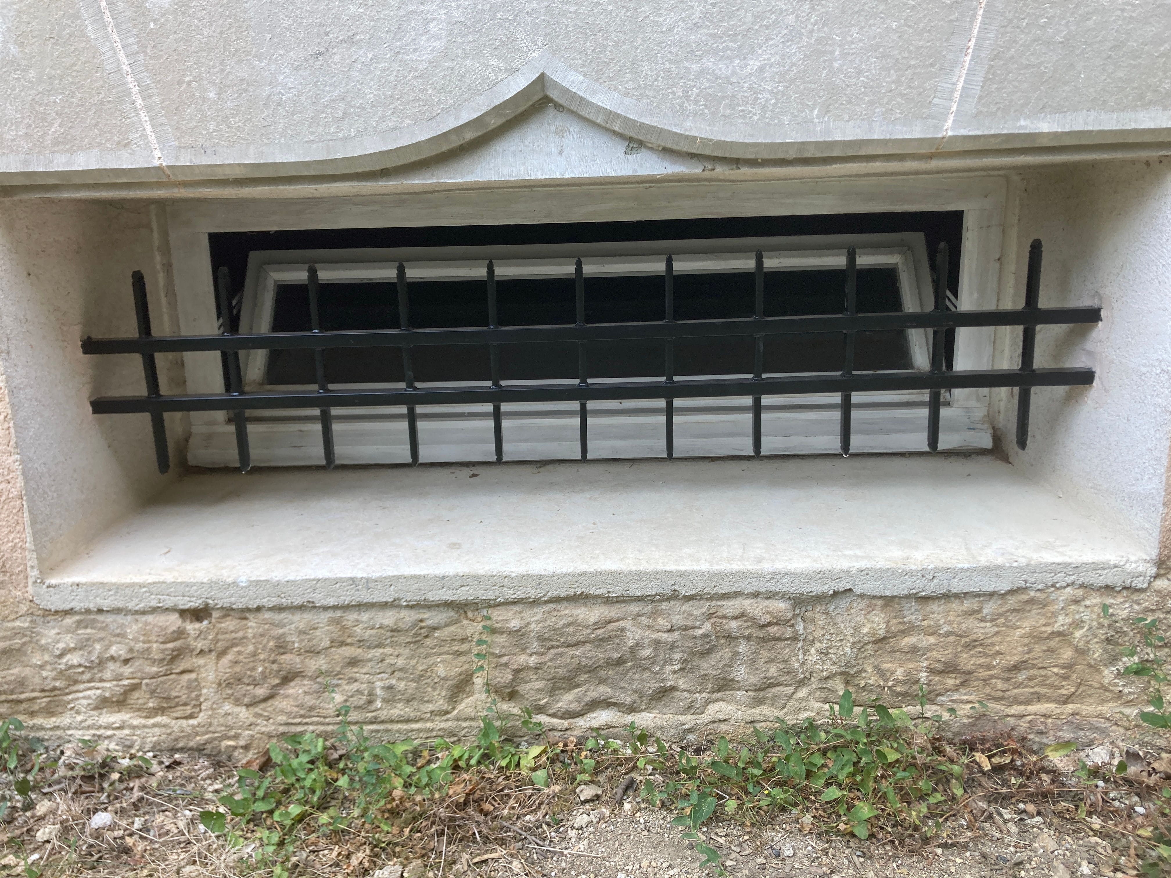 Fabrication et pose de grille de défense en fer forgé sur une ancienne école catholique des années 1900 transformée en habitation. le barreaudage est verticale, l'extrémité de chaque barreaux est en forme de goutte d'eau façonnée à la main. Les grilles sont scellées dans les encadrements des fenêtres. Le lot de 8 grilles a été fabriqué identique aux grilles existantes. L'ensemble est peint en ral 9005 noir et s'intègre parfaitement au bâtiment. Grilles de défense métallique réalisées et installées par l'entreprise Claude Jeandin métallerie.